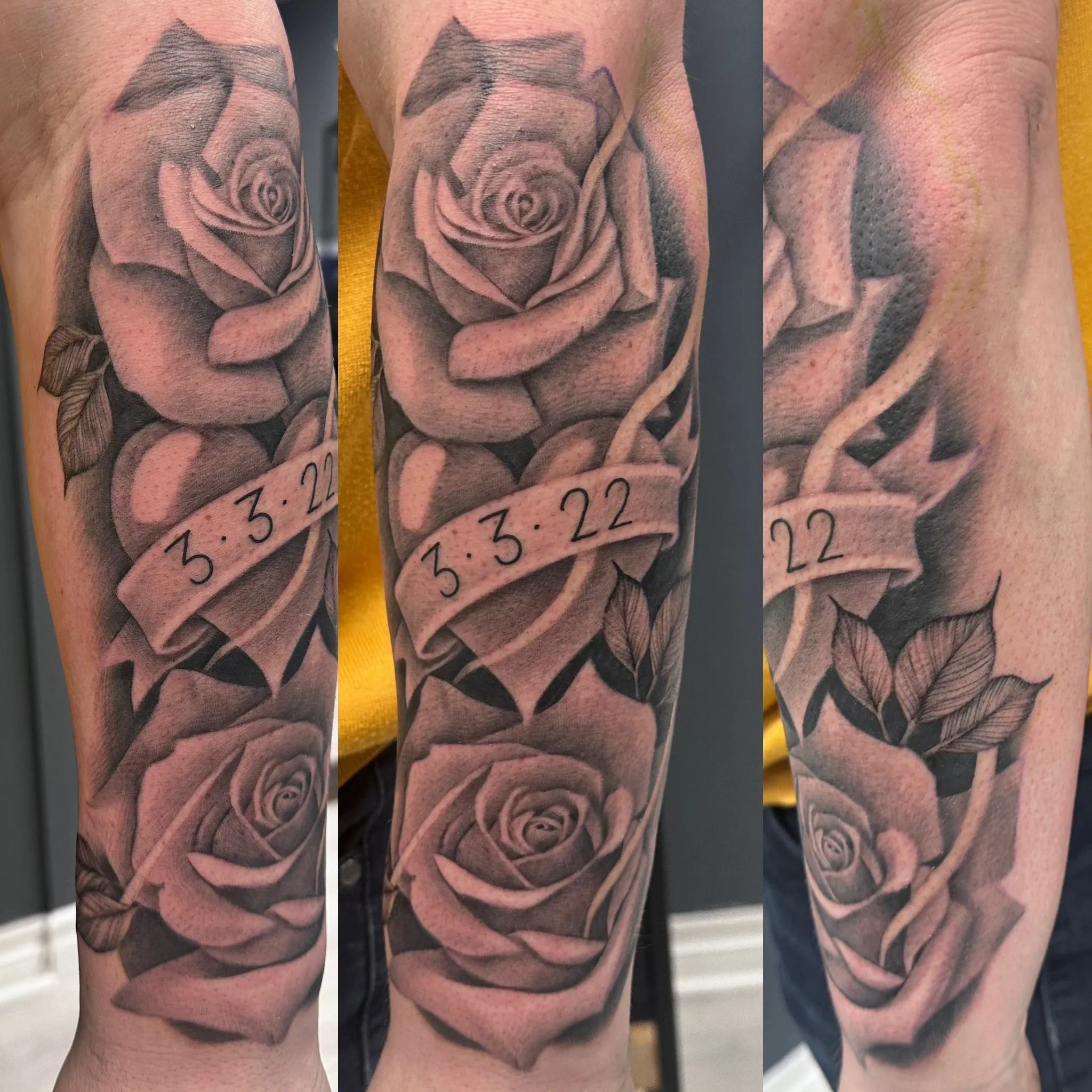 Svart-hvitt tatovering av en stor rose med et bånd som viser datoen “3.3.22”, detaljerte skygger og blader rundt.