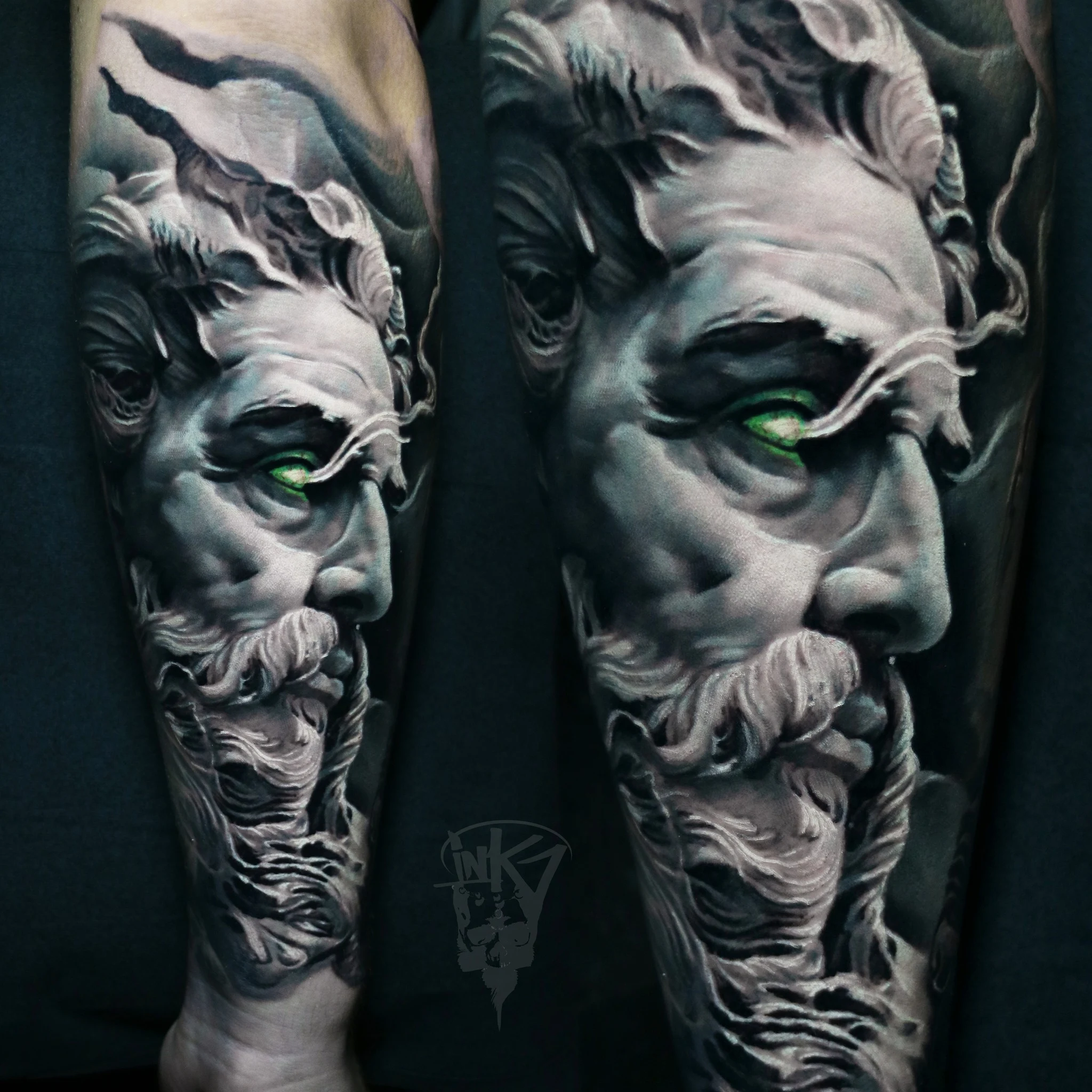 Realistisk tatovering av et ansikt med hvitt skjegg og bølgende hår i klassisk skulptur-stil, der det ene øyet lyser i intens grønn farge, noe som skaper en dramatisk kontrast mot de mørke og lyse gråtonene.